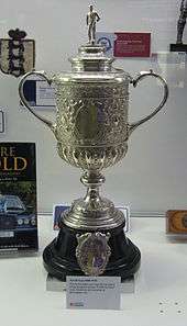 A trophy, silver in colour and topped by a figure of a footballer, on an ebony plinth