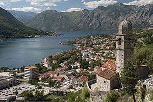 A town in rocky mountains next to a bay or lake.