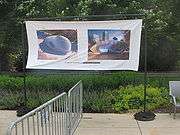 A banner depicting two perspectives of a sculpture