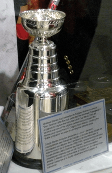 A small silver bowl atop of a large cylindrical base.