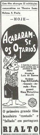 Movie poster featuring an illustration of a goateed man wearing a straw hat, plaid shirt, short polka-dotted tie, short pants, and boots. The accompanying text is in Portuguese.