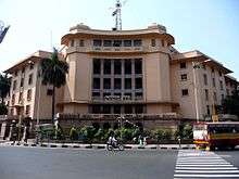 A five storied building in cream colour with multiple columns in front