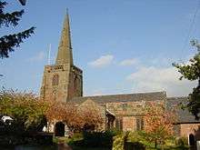 A sandstone church seen from the south with a west tower and a recessed spire