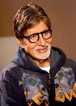 Amitabh Bachchan is smiling at the camera