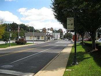 Photo of a suburban road approaching a railroad crossing