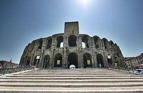 A large stone amphitheatre which is surrounded by many buildings.