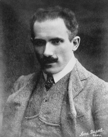 head and shoulder shot of youngish man with dark hair and moustache