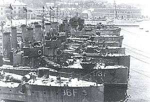 black and white photograph of several vessels alongside each other at a dock