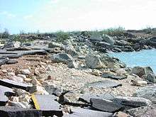 A crumbled roadway at the water's edge