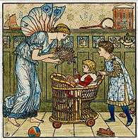 a tall female fairy in a draped gown passing a posey of flowers to a small child in a wicker push chair pushed by an older child wearing a green dress and a patterned pinafore against a nursery background with cupboards and toys