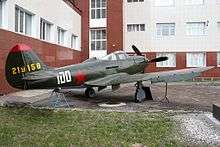 a green monoplane with a red star on the fuselage