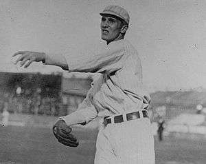 A black-and-white photograph of a man following through after throwing a baseball