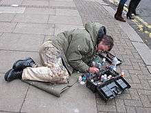 Man lying on pavement, painting chewing gum