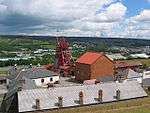 A small mining site overlooking a small city and large fields.