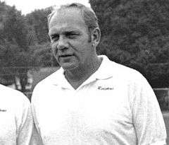 Candid black and white chest-up photograph of Austin wearing a white Redskins polo-style shirt