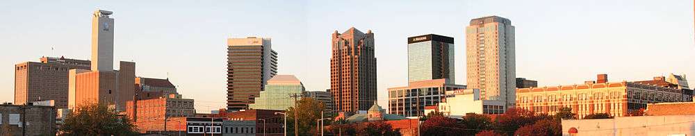 Panoramic view of a city's skyline. In the distance, there is a city skyline with several skyscrapers of varying heights.