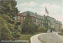 A colored postcard of a red brick building