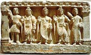 An early Mahayana Buddhist triad. From left to right, a Kushan devotee, the Bodhisattva Maitreya, the Buddha, the Bodhisattva Avalokitesvara, and a Buddhist monk. from the 2nd-3rd century AD