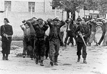 Captured men, with hands behind their heads