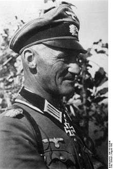 A man wearing a military uniform with an Iron Cross displayed at the front of his uniform collar.