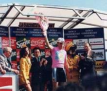 A man holding flowers while wearing a pink jersey.