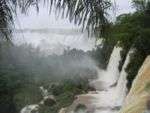 A large waterfall in a densely vegetated area.