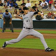 A man in a grey baseball uniform with "FLORIDA 41" on the chest and a black baseball glove on his left hand pitching a baseball right-handed.