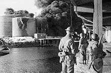 Men in British Army uniform on quayside looking across the fiord