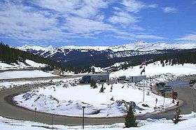 A parking lot with a view of several snow-capped mountains