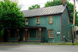 A teal house with red and gold trim