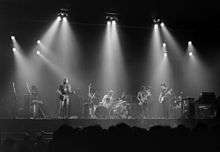 A black and white photo of four men performing onstage.