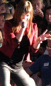 Young, smiling woman singing on stage