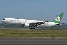 Aircraft in flight. Side view of twin-engine jet with extended landing gear and flaps.