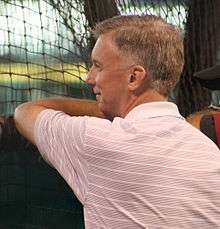 A man with short gray hair and a striped polo shirt seen in profile