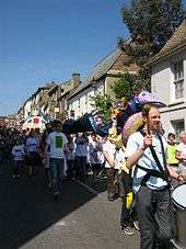 Eel day parade view down Fore Hill showing people in white Eel day tee-shirts walking towards the camera