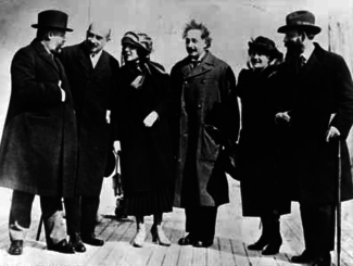 Casual group shot of four men and two women standing on a brick pavement.