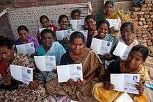 Women smile with their land titles