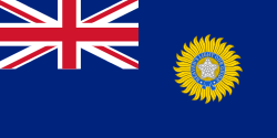 A British blue Ensign (a blue flag with the Union Jack placed at the top left corner) charged with the Star of India (five pointed star inside a circular band tied at the bottom)