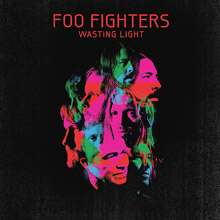 A collage of green, blue and pink face pictures of the Foo Fighters members against a black background. Above it is the title "FOO FIGHTERS - WASTING LIGHT" in red letters.