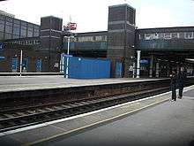 Outdoor station with enclosed, overhead walkway