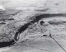 Aerial view of a river cutting a canyon through a rocky plateau.