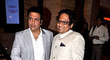 A serious Govinda with a smiling man