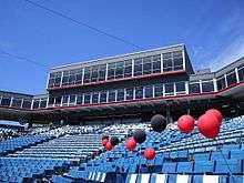 A view of the concourse behind home plate. Overlooking the field are sky boxes and the press box on the third floor and the fourth floor stadium restaurant, all of which are fronted by glass windows.