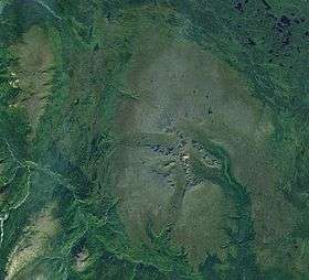 Landscape of a flat plain with two groups of mountains.