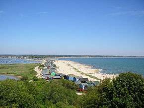 view looking down from a hill onto a sandy shoreline