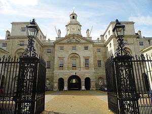 A grand building behind tall, black gates