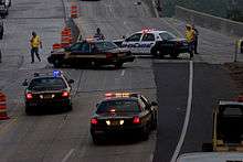 Four persons running and about four police cars from various services