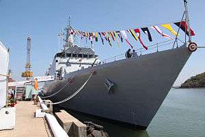 Large ship with many pennants at a dock