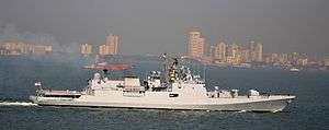 Long, white ship against the Mumbai skyline