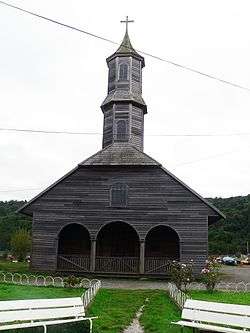 Wooden church with a single central tower covered in shingles.